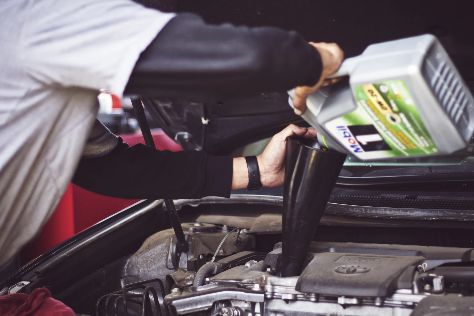 Mechanic tools laid out beside an open car engine bay