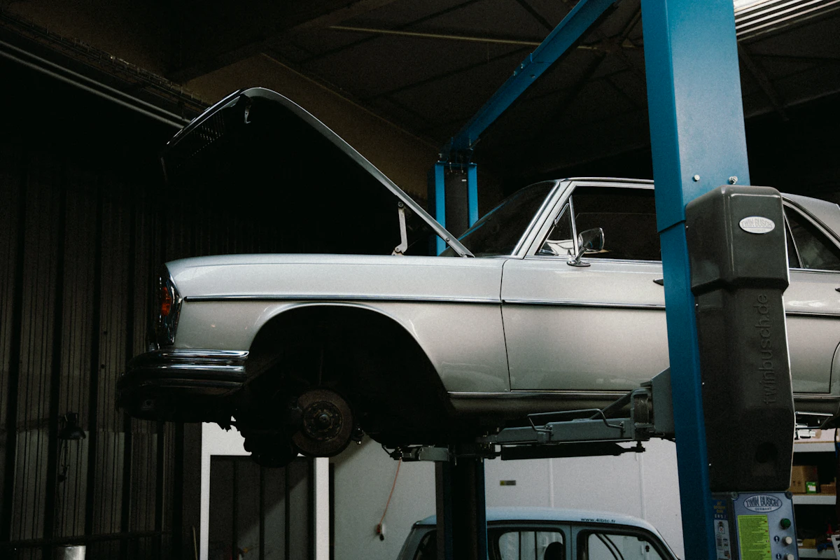 Car raised on a lift inside a tidy garage workshop